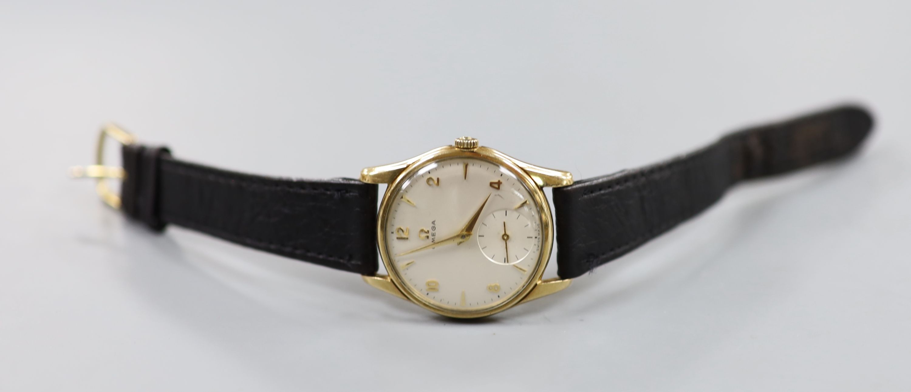 A gentleman's 9ct gold Omega manual wind wrist watch, on associated leather strap, with case back inscription, case diameter 33mm, gross weight 35.1 grams.